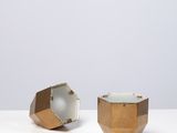 deux vases dorés et blancs posés sur une table blanche