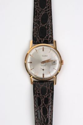 une image d'un gros plan d'une montre-bracelet sur une surface blanche