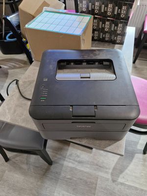 a printer sitting on top of a desk next to a chair