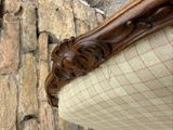 a close up of a chair with a stone wall in the background