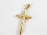 a close up of a gold cross on a white surface