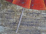 a red umbrella that is sitting on the side of a building