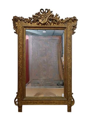 Grand miroir en bois et stuc dorée à décor feuillagé, ornée …