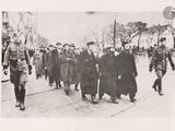 black and white photograph of a group of men walking down a street