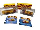 Trois camions miniatures sont posés les uns à côté des autres sur une surface blanche.