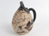 a vase with a picture of a man sitting on a chair