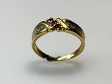 gros plan d'une bague en or avec une pierre en rubis