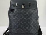 un gros plan d'un sac à dos Louis Vuitton noir posé sur une table