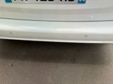 the back end of a white car with a license plate on it