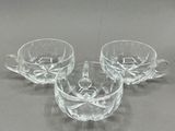 trois tasses et soucoupes en verre transparent posées sur une table