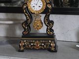 une horloge posée sur une table devant un miroir
