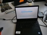 un ordinateur portable posé sur un bureau, à côté d'autres ordinateurs portables