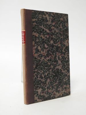 an old book sitting on top of a white table next to a white wall