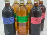 six bouteilles de vin sont alignées sur une surface blanche
