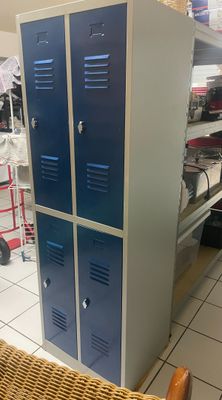 deux casiers bleus dans une pièce où se trouve une chaise en osier