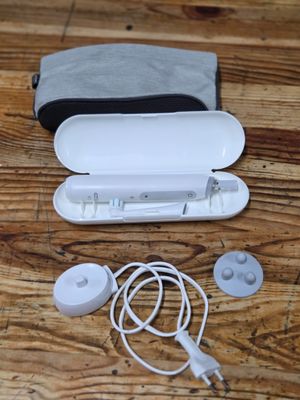 a bag with ear buds and a remote on a wooden table