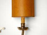 an image of a wall light with a leather shade on it