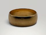 a close up of a gold ring on a white surface