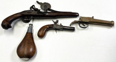 trois vieilles armes à feu sont exposées sur une surface blanche, devant un fond blanc