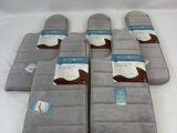 six gray and white bath mats with a cow design on them
