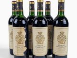 four bottles of wine are lined up on a white surface