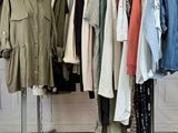 a lot of clothes hanging on a rack in a room