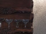 a wooden shelf with wine glasses on top of it