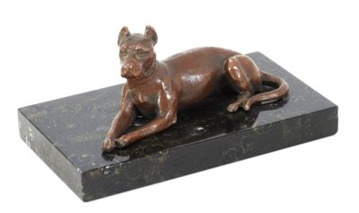 statue of a dog laying on a black marble base