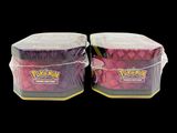 two containers of pokemon cards are wrapped in clear plastic