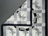 a black and white quilt with a dog design on it