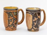 deux tasses à café posées l'une à côté de l'autre sur une surface blanche