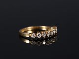 a gold ring with five diamonds on a black surface