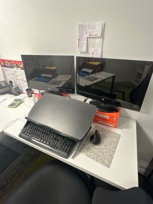 un bureau sur lequel sont posés deux écrans et un ordinateur portable