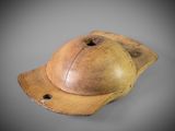 an old wooden baseball cap with a leather visor on a gray background
