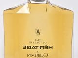 a close up of a bottle of perfume on a white surface