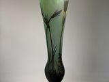 a green glass vase with a black base on a white background