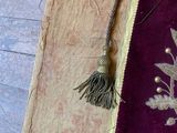a purple and gold banner with a tassel hanging from it