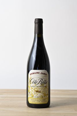 une bouteille de vin rouge posée sur une table en bois