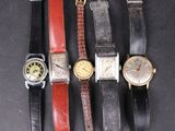 Plusieurs modèles de montres sont exposés sur un fond noir