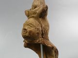 sculpture of a head of a bear on a stand against a cloudy sky