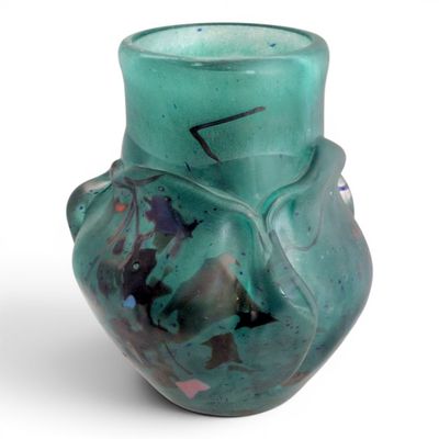 a green vase that has a design on it