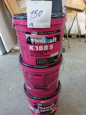 Plusieurs seaux de peinture rose sont empilés les uns sur les autres