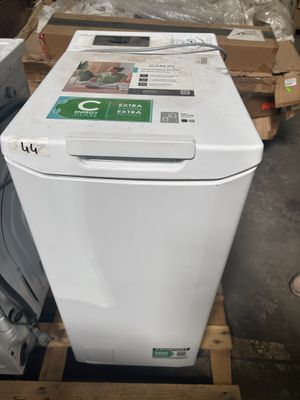a white dishwasher sitting on a pallet in a warehouse