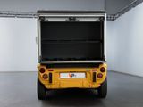 the back end of a yellow golf cart in a white room