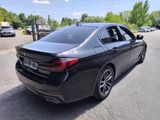 a black bmw sedan parked on the side of the road