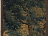 une tapisserie accrochée au mur d'une pièce où se trouve un tableau