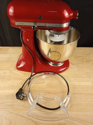 une photo d'un mixeur rouge posé sur une table en bois