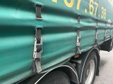 un semi-remorque vert garé sur le bord de la route
