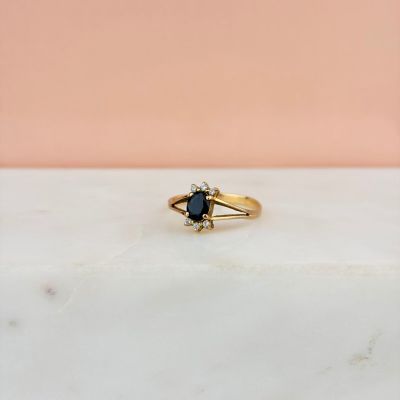 gros plan d'une bague en or avec un diamant noir