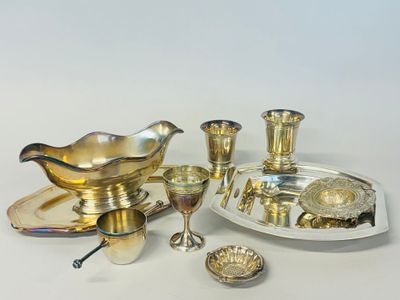 an assortment of silver plated items including a bowl, saucer, spoon, and other items